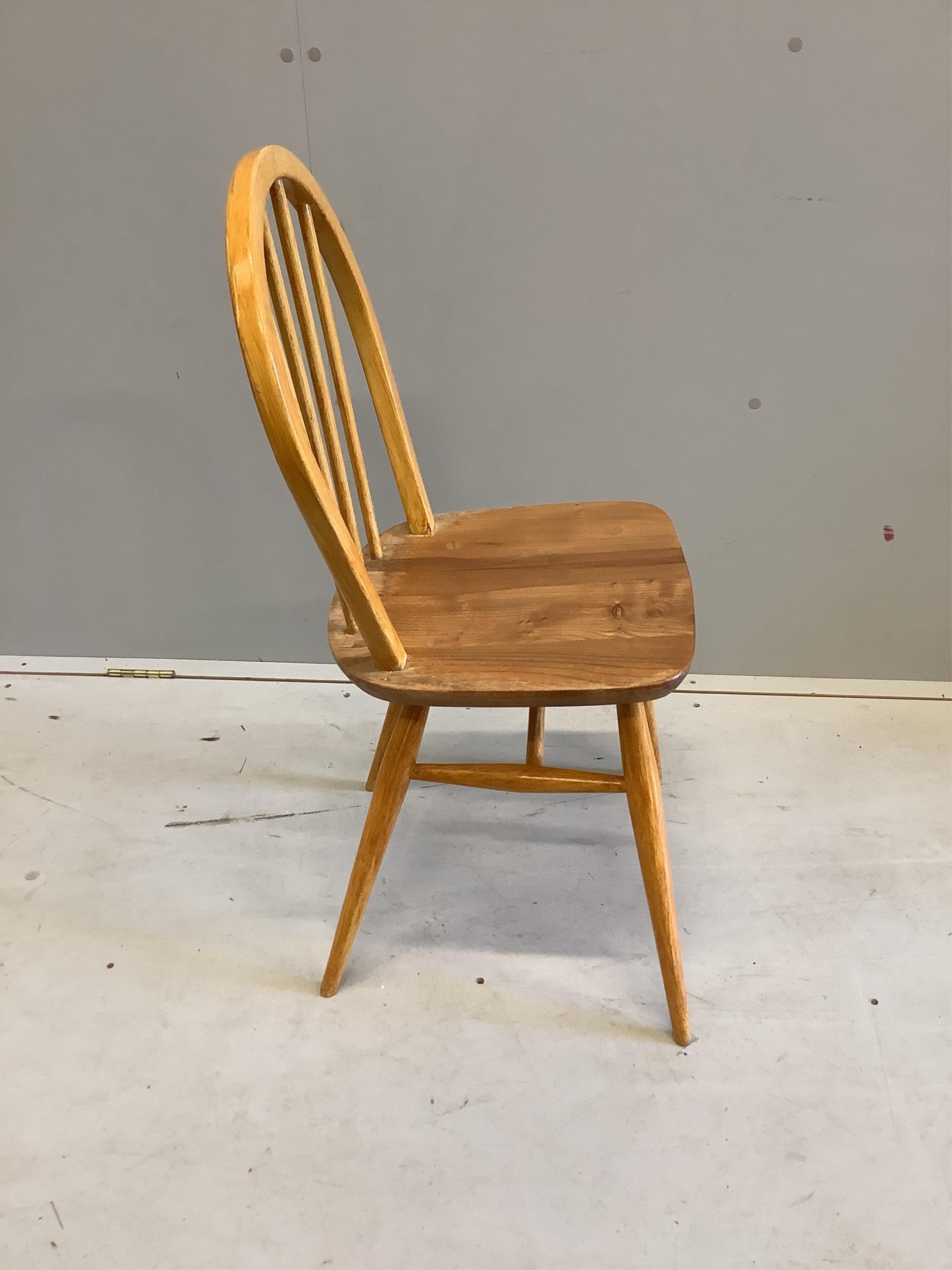 A set of four mid century Ercol style elm and beech comb back dining chairs, height 85cm. Condition - poor to fair